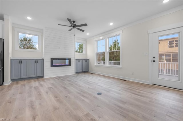 unfurnished living room featuring ornamental molding, ceiling fan, and light hardwood / wood-style floors