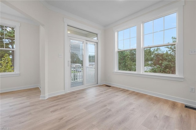 empty room featuring crown molding and light hardwood / wood-style flooring