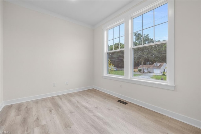 unfurnished room featuring crown molding and light hardwood / wood-style floors