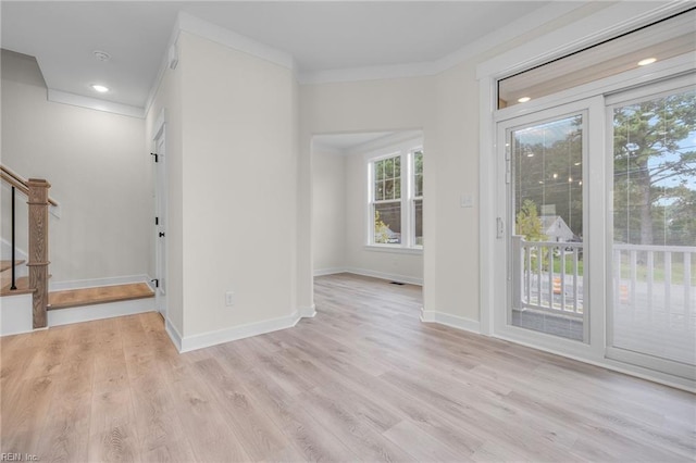 unfurnished room featuring ornamental molding, a healthy amount of sunlight, and light hardwood / wood-style flooring