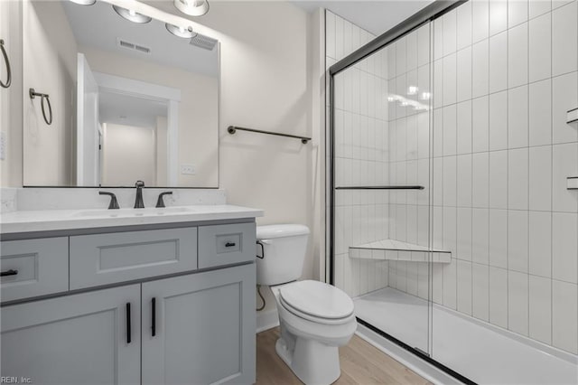 bathroom featuring walk in shower, vanity, toilet, and hardwood / wood-style floors