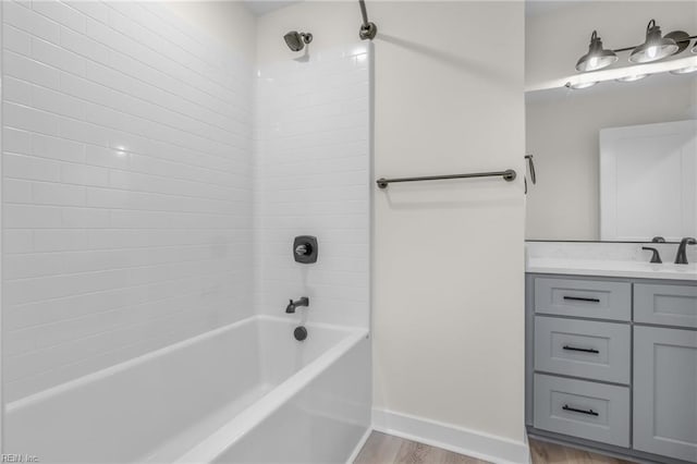 bathroom with tiled shower / bath, hardwood / wood-style floors, and vanity