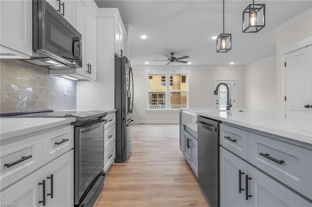 kitchen with pendant lighting, white cabinetry, black refrigerator, stainless steel dishwasher, and electric stove