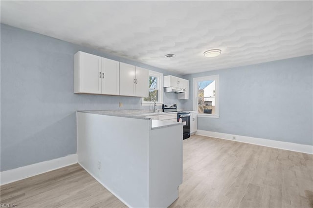 kitchen with stainless steel range with electric stovetop, light hardwood / wood-style flooring, white cabinets, and sink