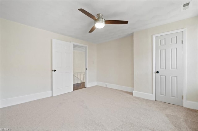 unfurnished bedroom featuring ceiling fan, light carpet, and a closet