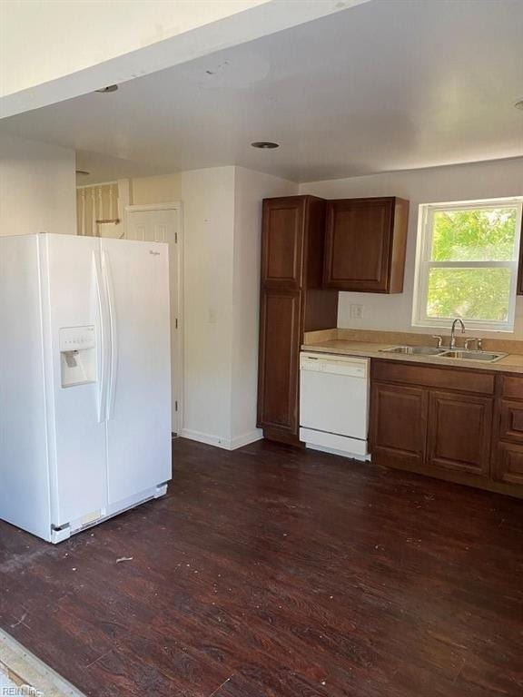 kitchen with sink, dark wood-type flooring, and white appliances