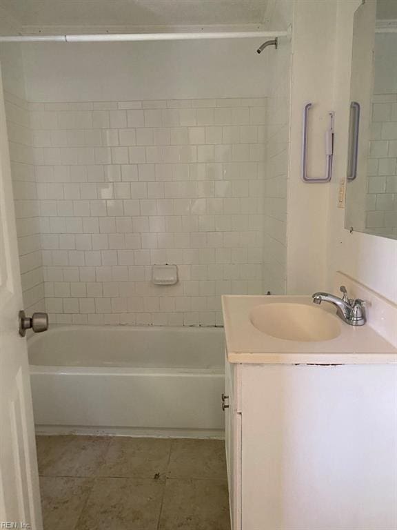 bathroom with tile patterned floors, vanity, and tiled shower / bath