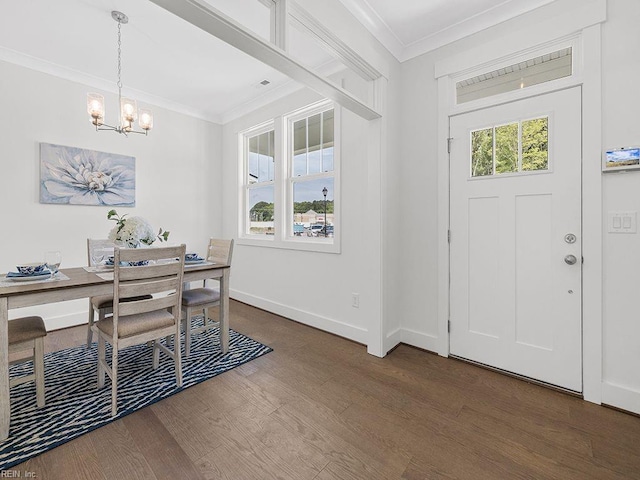 foyer entrance with dark hardwood / wood-style floors, crown molding, and an inviting chandelier