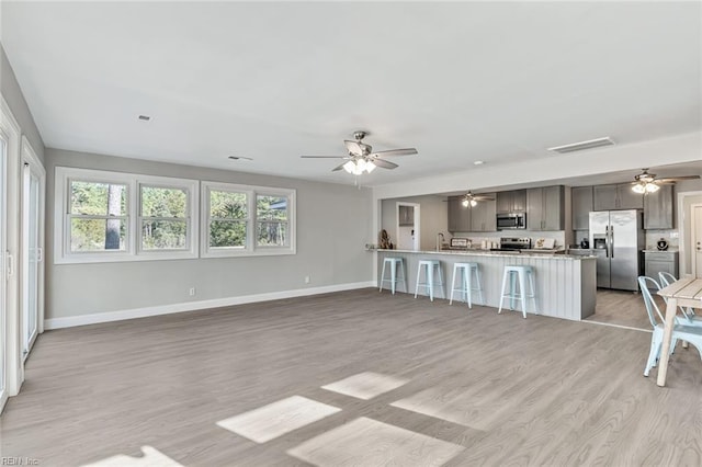 unfurnished living room with light hardwood / wood-style flooring and sink