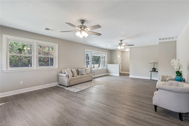 living room with ceiling fan and dark hardwood / wood-style flooring