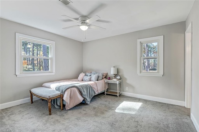 carpeted bedroom featuring multiple windows and ceiling fan