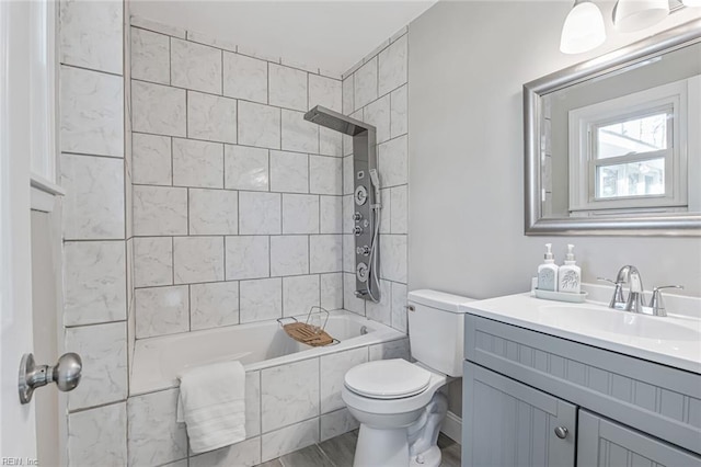 full bathroom featuring vanity, tiled shower / bath combo, and toilet