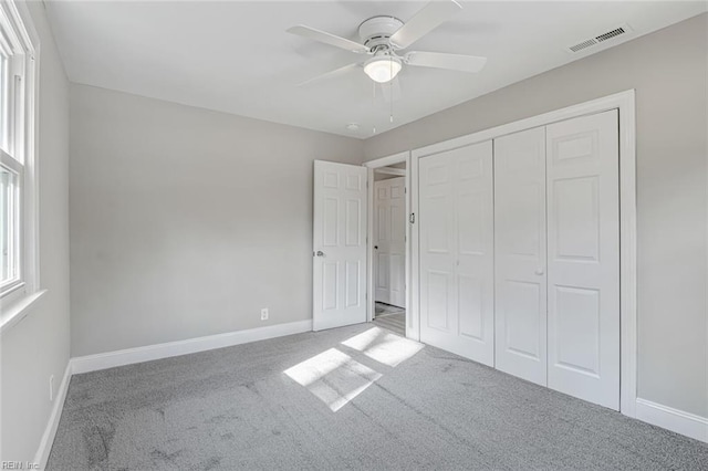 unfurnished bedroom featuring carpet, ceiling fan, and a closet