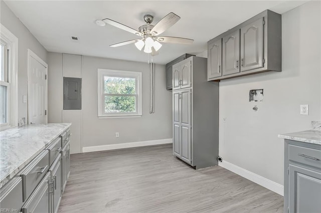 kitchen with gray cabinetry, ceiling fan, electric panel, and light wood-type flooring