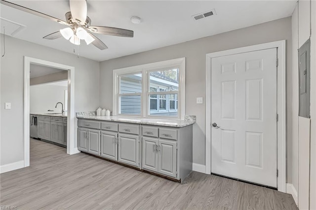 kitchen featuring light hardwood / wood-style floors, gray cabinetry, ceiling fan, sink, and electric panel