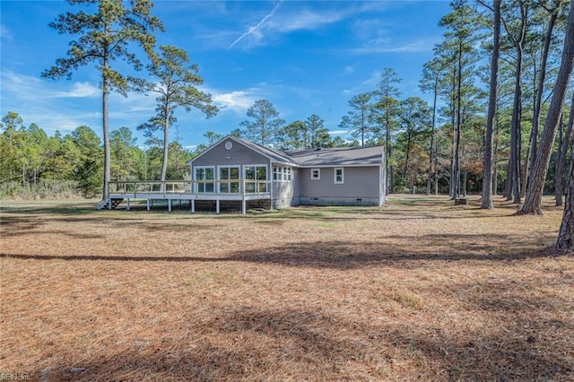 back of house featuring a yard and a wooden deck