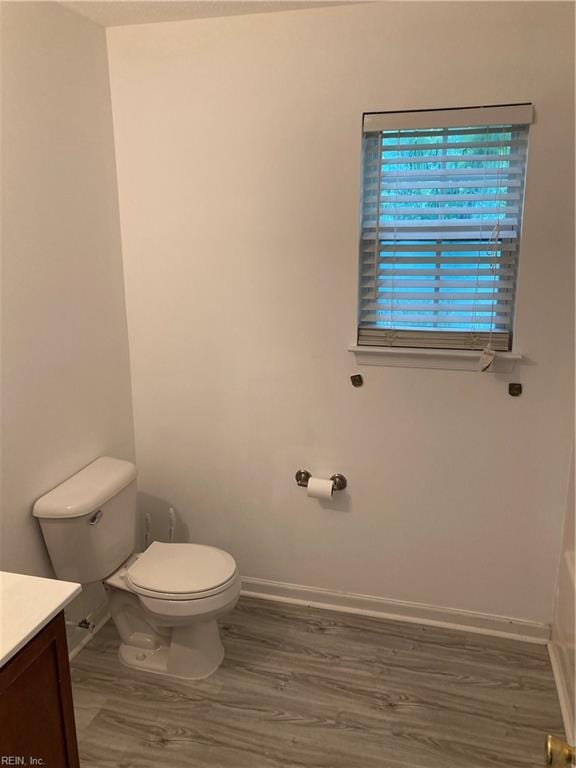 bathroom with hardwood / wood-style floors, vanity, and toilet