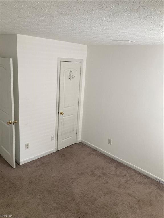 spare room featuring carpet floors and a textured ceiling