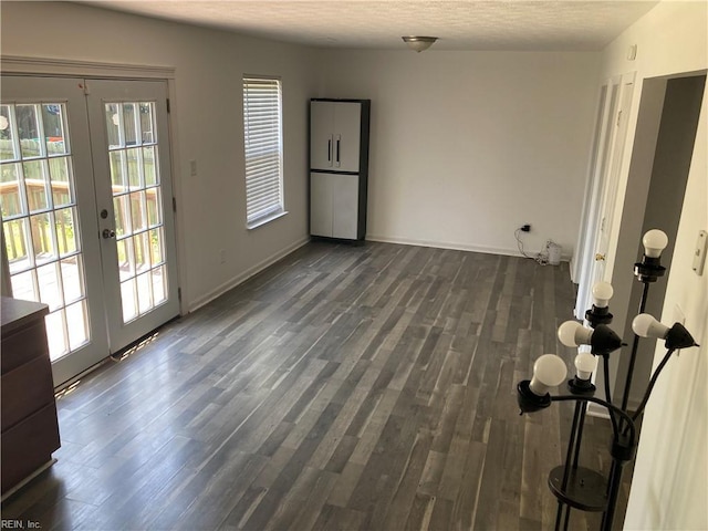 spare room with french doors, a textured ceiling, and dark hardwood / wood-style floors