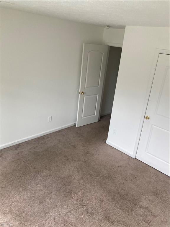 carpeted spare room with a textured ceiling