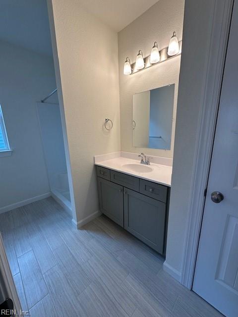 bathroom with vanity and a shower