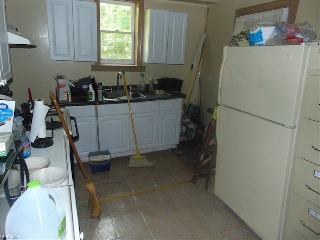 kitchen featuring white cabinets, light tile patterned floors, white refrigerator, and sink