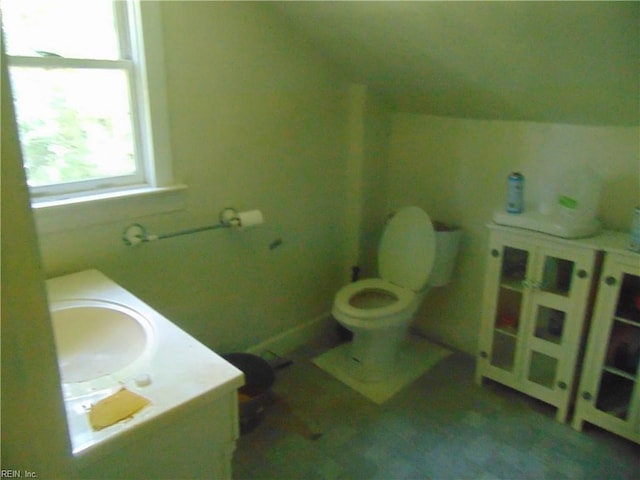 bathroom with sink, toilet, and vaulted ceiling