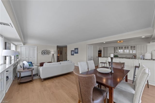 dining space featuring light hardwood / wood-style flooring and ornamental molding