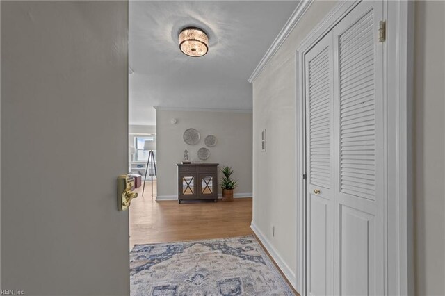 hall with hardwood / wood-style flooring and ornamental molding