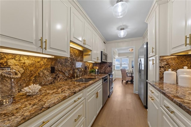 kitchen with white cabinetry, tasteful backsplash, stainless steel appliances, sink, and light hardwood / wood-style floors