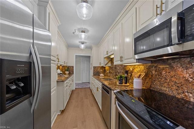 kitchen featuring dark stone counters, white cabinetry, tasteful backsplash, stainless steel appliances, and light hardwood / wood-style floors