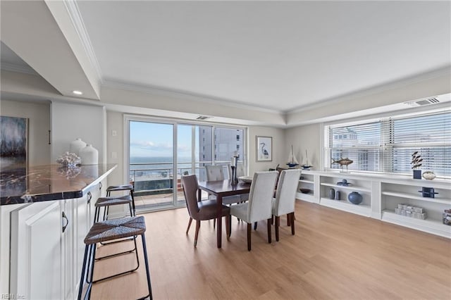 dining space featuring light hardwood / wood-style floors and ornamental molding