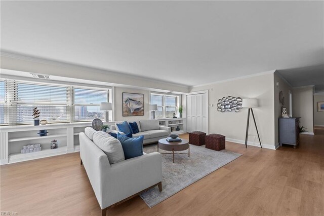 living room with hardwood / wood-style flooring and crown molding