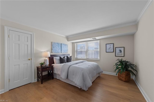 bedroom with wood-type flooring and ornamental molding