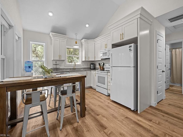 kitchen featuring white appliances, light wood-type flooring, and white cabinets