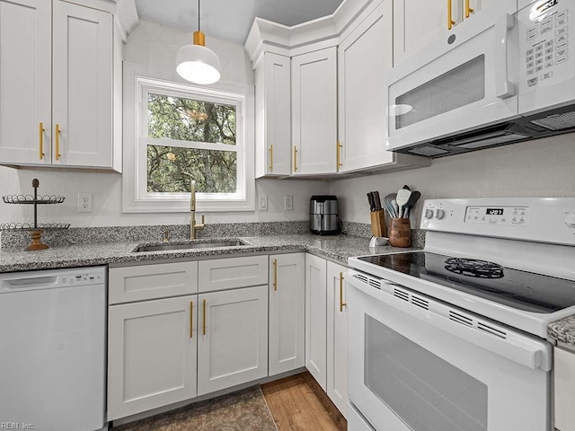 kitchen with sink, white cabinets, hanging light fixtures, light stone counters, and white appliances