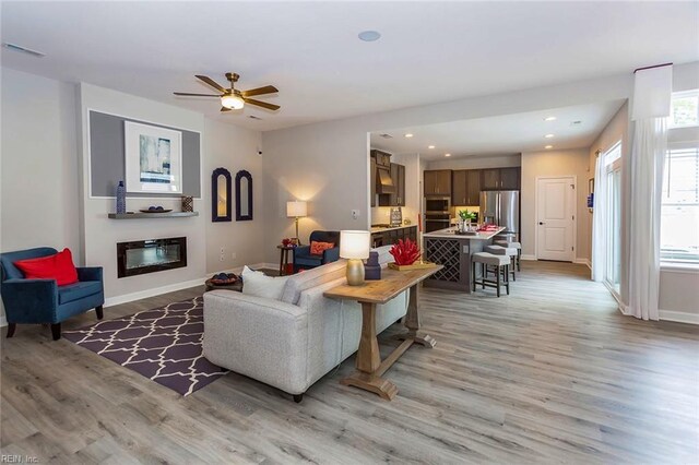 living room featuring a healthy amount of sunlight, ceiling fan, and hardwood / wood-style floors