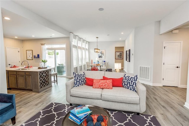 living room with sink and light wood-type flooring