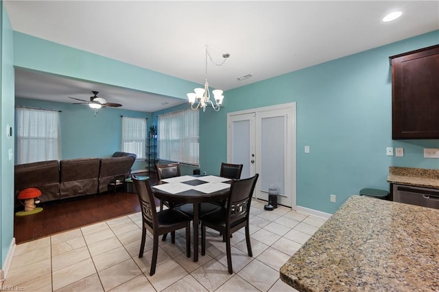 dining room with light hardwood / wood-style flooring and ceiling fan with notable chandelier