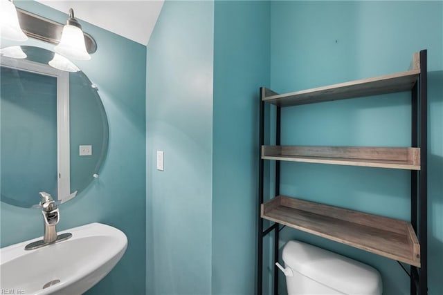 bathroom featuring vaulted ceiling, sink, and toilet