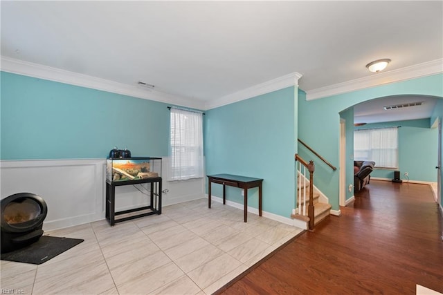 living area featuring ornamental molding and light hardwood / wood-style floors