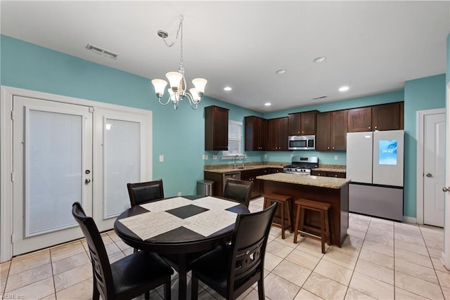 tiled dining room featuring sink and a chandelier