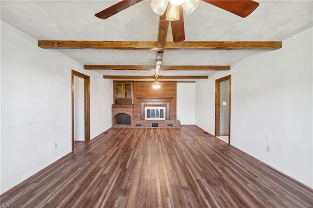 unfurnished living room featuring a fireplace, beamed ceiling, ceiling fan, and dark hardwood / wood-style floors