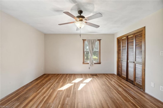 unfurnished bedroom featuring a closet, ceiling fan, and hardwood / wood-style floors