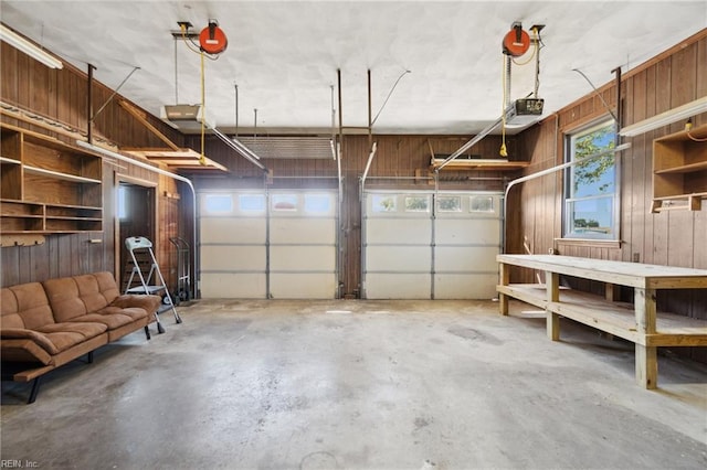 garage featuring a garage door opener and wood walls