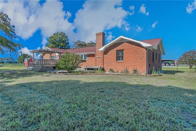 view of home's exterior with a pergola, a yard, and a deck