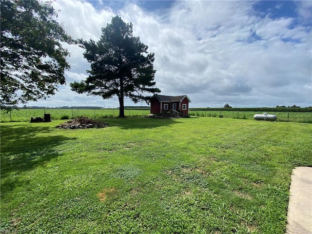 view of yard with a rural view and a storage shed