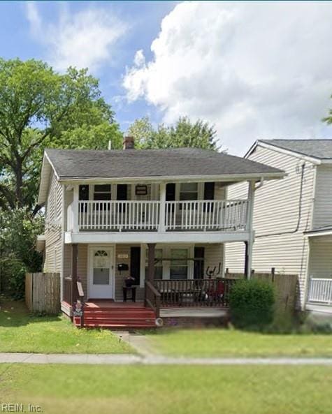 exterior space with a balcony, covered porch, and a lawn