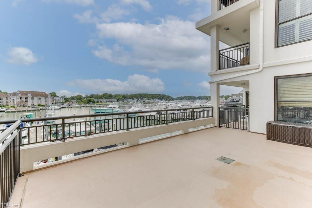 view of patio with a balcony and a water view