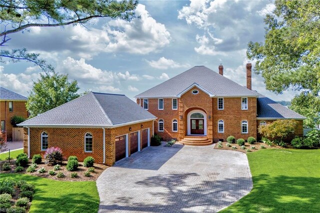 colonial home featuring a garage and a front yard